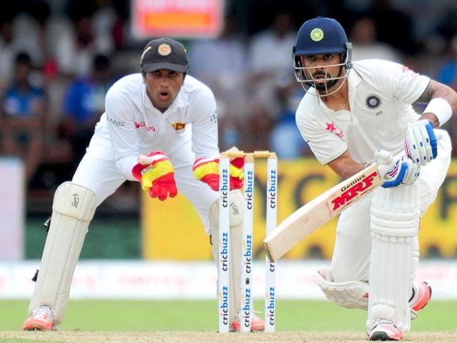 Indian cricket captain Virat Kohli (R) plays a shot as Sri Lankan wicketkeeper Dinesh Chandimal looks on during the opening day of their second test match between Sri Lanka and India at the P Sara Oval Cricket Stadium in Colombo. (AFP Photo)