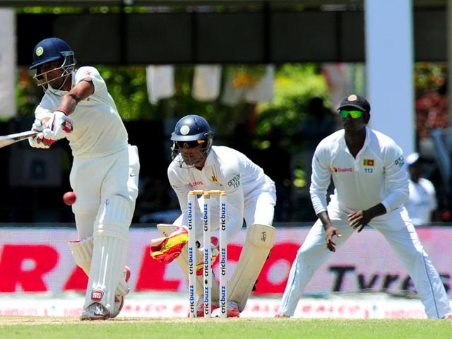 India's Wriddhiman Saha (L) plays a shot as Sri Lankan wicketkeeper Dinesh Chandimal (C) and captain Angelo Mathews (R) look on. (AFP Photo)
