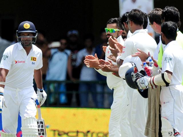 Sri Lankan cricketer Kumar Sangakkara (L) is congratulated by Indian cricket captain Virat Kohli and teammates as he arrives to bat during the second day of the second test match between Sri Lanka and India at the P Sara Oval Cricket Stadium in Colombo. (AFP Photo)
