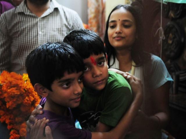 Nishant Zope hugs his elder brother as their mother looks on after his return home in Bhopal on Sunday. (Mujeeb Faruqui/HT)