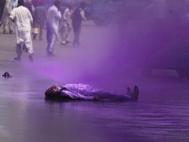A member of Tehreek-e-Hurriyat (TeH) lying on ground as police use water canons to disperse the protestors in in Srinagar on Sunday. Abid Bhat/HT