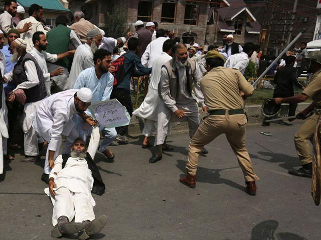 Police trying to detain supporters of the hardline faction of the All Parties Hurriyat Confrence (APHC) as they clash during a protest following the house arrest of APHC leader, Syed Ali Shah Geelani in Srinagar on Sunday. Abid Bhat/HT