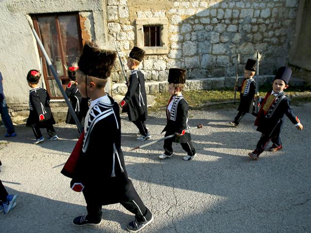 Children walk past houses before the start of the Children's Alka competition in Croatia. (Reuters)