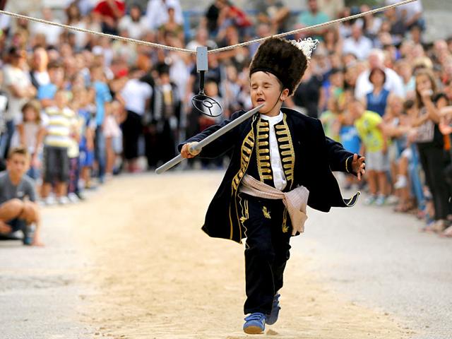 Another child participates in Children's Alka competition, commemorating the victory over the Ottoman Turkish administration. (Reuters)