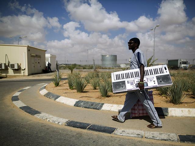 An African migrant carries belongings after being released from Holot detention centre in Israel's southern Negev desert. (Reuters Photo) An African migrant carries belongings after being released from Holot detention centre in Israel's southern Negev desert. (Reuters Photo)