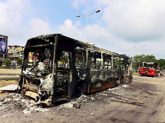 The charred remains of buses in Ahmedabad on Wednesday which were set on fire during the Patidar community's agitation on Tuesday night. (PTI Photo)
