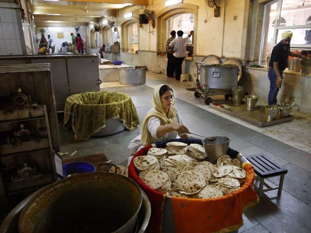 A woman puts butter on Indian breads before serving it during langar at the Bangla Sahib Gurdwara in New Delhi. (AP Photo/Manish Swarup) A woman puts butter on Indian breads before serving it during langar at the Bangla Sahib Gurdwara in New Delhi. (AP Photo/Manish Swarup)