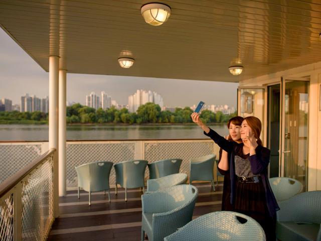Two women take a selfie on the deck of the tour boat. (AFP Photo)