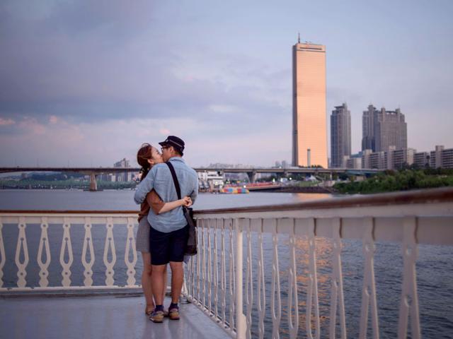 A couple kiss as they stand on the deck of the tour boat. (AFP Photo)