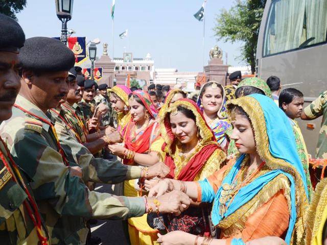 Girls tying rakhis on the wrists of Border Security Force (BSF) jawans on the occasion of Raksha Bandhan at Wagah border in Amritsar on Saturday. Sameer Sehgal/HT