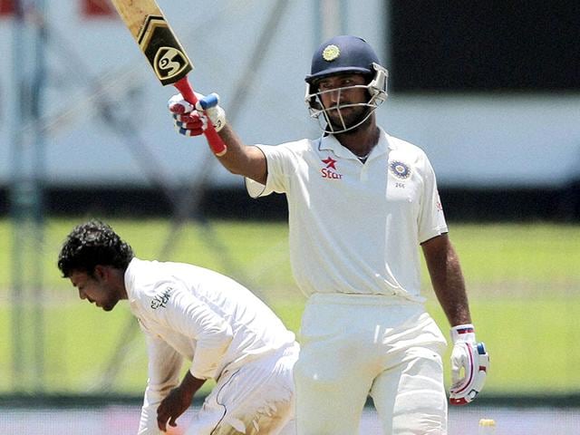 Pujara, right, celebrates scoring his half-century. (AP Photo)