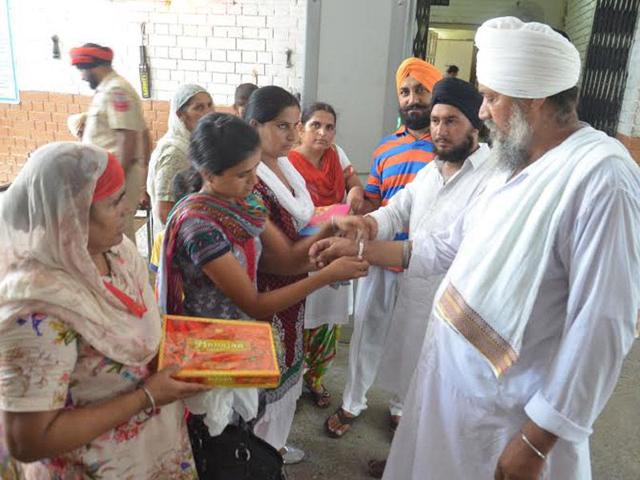 Women tying rakhi to their brothers at Central Jail in Amritsar on Saturday. Sameer Sehgal/HT