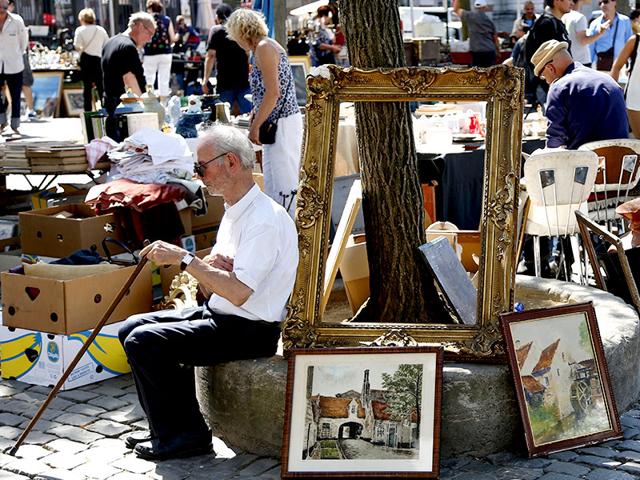 A man sits near paintings on the Place du Jeu de Balle during the daily flea market with second-hand clothes, books and bric-a-brac in Brussels. (Francois Lenoir/Reuters) A man sits near paintings on the Place du Jeu de Balle during the daily flea market with second-hand clothes, books and bric-a-brac in Brussels. (Francois Lenoir/Reuters)