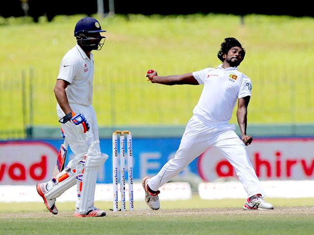 Pradeep bowls as Sharma, left, watches from the non-striker's end. (AP Photo)