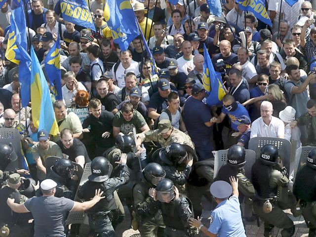 Demonstrators, who are against a constitutional amendment on decentralization, clash with police outside the parliament building in Kiev, Ukraine. (Reuters Photo)