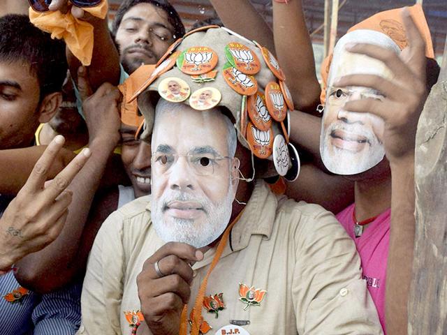 BJP supporters wear Prime Minister Narendra Modi's mask at NDA's Parivartan Rally at the Airport Ground in Bhagalpur. (PTI Photo)