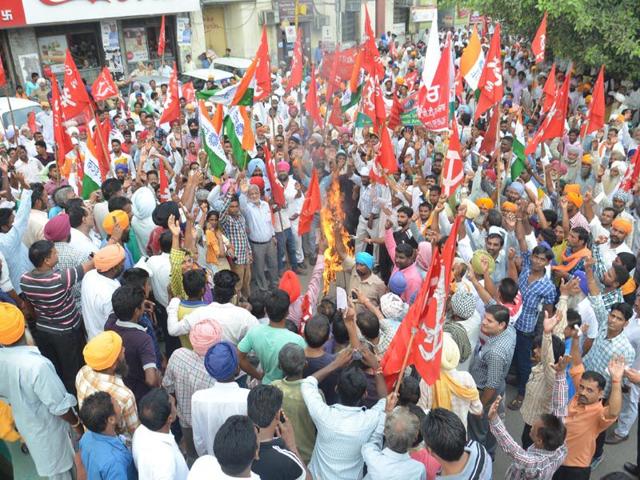 Activists of various trade unions burning effigy of Prime Minister Narendra Modi during a strike to protest against the proposed labour reforms by Central Government at Town Hall in Amritsar on Wednesday. (Sameer Sehgal/HT)