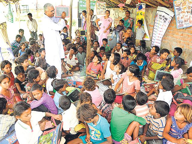 Like his personality, Chandra Tiwari's classes are also out of the box. He assembles children of all age groups and teaches different things to different groups at the same time. (Deepak Gupta/HT Photo) Like his personality, Chandra Tiwari's classes are also out of the box. He assembles children of all age groups and teaches different things to different groups at the same time. (Deepak Gupta/HT Photo)