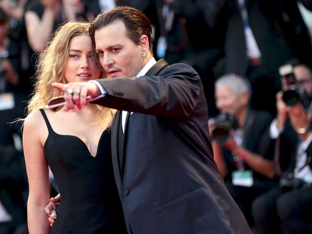 Impeccably dressed in a midnight blue tuxedo, Johnny displayed his handsome looks while grabbing hold of his wife while posing.