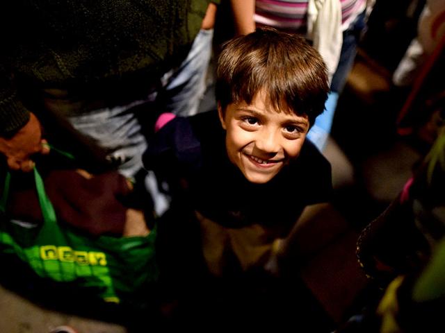 A migrant boy smiles between others at the railway station in Saalfeld, eastern Germany, after their arrival in a special train from Austria. (AFP Photo)