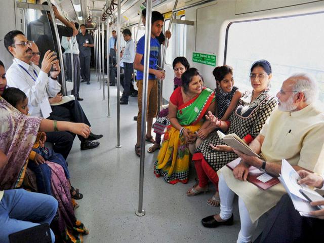 Prime Minister Narendra Modi interacts with fellow passengers in the Metro. (PTI Photo)