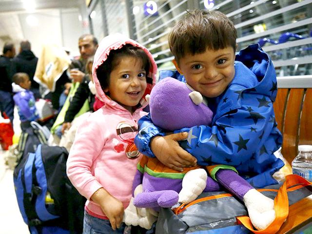 Two Syrian children laugh as they cuddle a stuffed toy given by well-wishers after they arrived in a train from Budapest's Keleti station at the airport in Frankfurt, Germany. Thousands of migrants were bussed to the Hungarian border by a right-wing government that had tried to stop them but was overwhelmed by the sheer numbers reaching Europe's frontiers. (Reuters Photo)