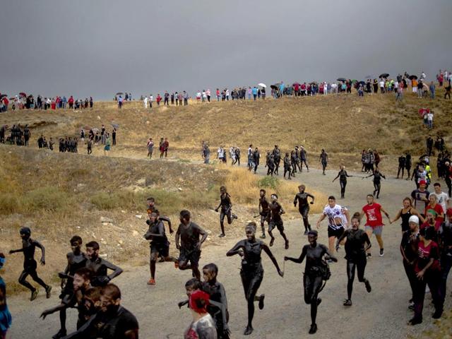 Every year on September 6, a villager from Guadix dresses as an oddball character called 'Cascamorras' and travels the three kilometres to the village of Baza, flanked by a team of representatives. (AFP Photo)