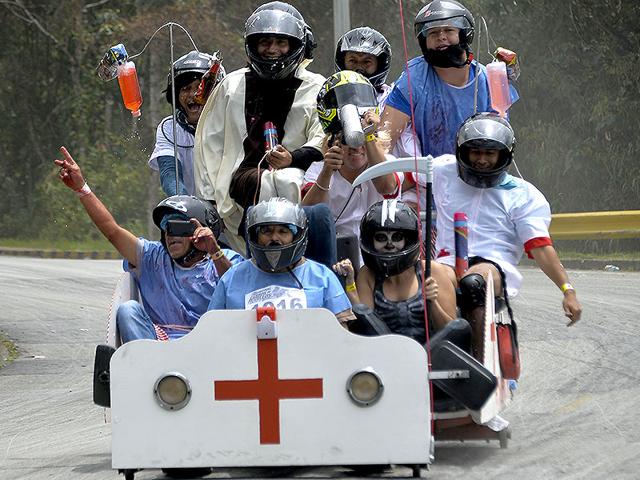 Participants in a homemade hospital-bed-shaped car during the XXVI Car Festival in Medellin, Colombia on September 6, 2015. (AFP)