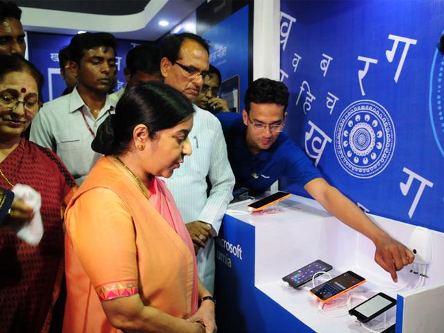 A Microsoft representative demonstrates smartphones with Hindi tools to Sushma Swaraj and Shivraj Singh Chouhan, in Bhopal on Tuesday. (Mujeeb Faruqui/HT)