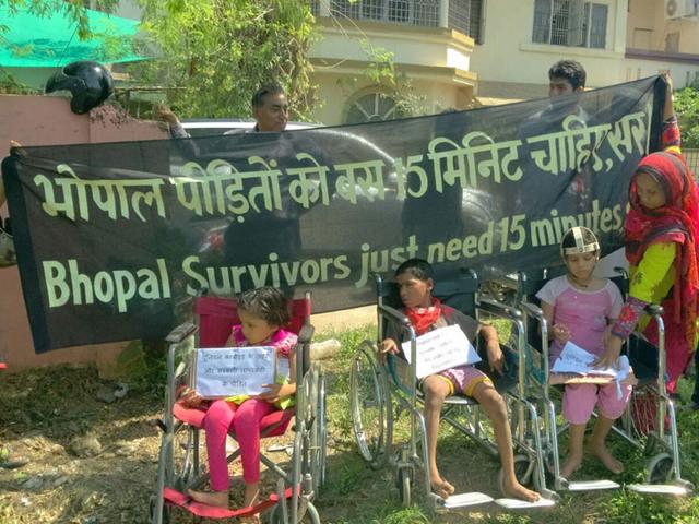 Differently-abled children from gas tragedy affected families wait with banners seeking PM's attention during his visit to Bhopal on Thursday. (HT photo)