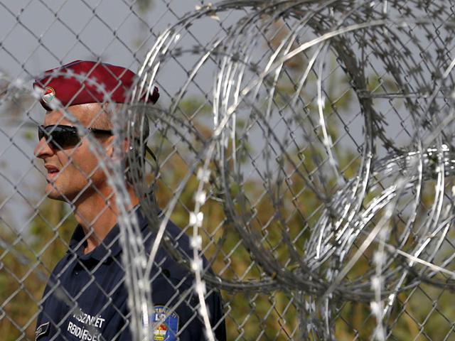 A Hungarian police officer guards a closed railway border crossing between Serbia and Hungary, near Horgos, Serbia. (AP Photo) A Hungarian police officer guards a closed railway border crossing between Serbia and Hungary, near Horgos, Serbia. (AP Photo)