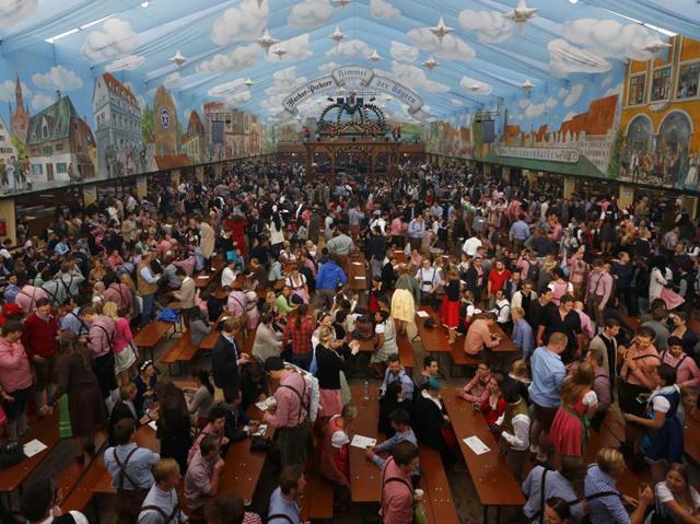 People rush to find seats in the "Hacker Pschorr" tent during the opening of the Oktoberfest beer festival in Munich on Saturday . (AP)