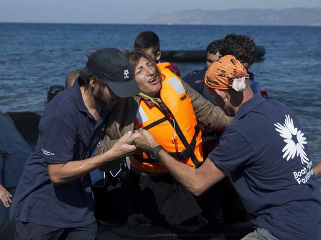 Volunteers help an Afghan woman after she arrived aboard a dinghy from Turkey, to the island of Lesbos, Greece. A girl, about five-years-old died and at least 13 undocumented refugees and migrants were missing after a boat overturned off Lesbos island. (AP Photo) Volunteers help an Afghan woman after she arrived aboard a dinghy from Turkey, to the island of Lesbos, Greece. A girl, about five-years-old died and at least 13 undocumented refugees and migrants were missing after a boat overturned off Lesbos island. (AP Photo)
