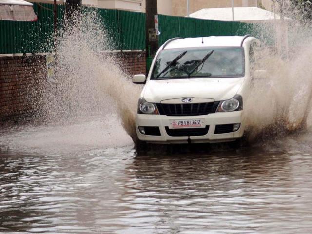 People wading through waterlogged road in Patiala on Sunday. (Bharat Bhushan/HT)