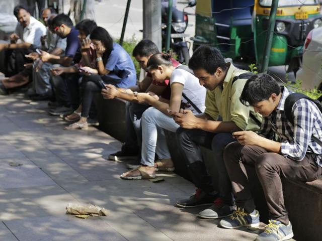 People use their mobile phones in New Delhi, India.The government backtracked on a proposed requirement for all messages sent on social media and mobile chatting apps to be saved for several months as a way of defeating encryption technology. (AP Photo) People use their mobile phones in New Delhi, India.The government backtracked on a proposed requirement for all messages sent on social media and mobile chatting apps to be saved for several months as a way of defeating encryption technology. (AP Photo)