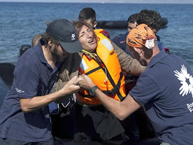 Volunteers help an Afghan woman after she arrived aboard a dinghy from Turkey, to the island of Lesbos, Greece. A girl, about five-years-old died and at least 13 undocumented refugees and migrants were missing after a boat overturned off Lesbos island. (AP Photo) Volunteers help an Afghan woman after she arrived aboard a dinghy from Turkey, to the island of Lesbos, Greece. A girl, about five-years-old died and at least 13 undocumented refugees and migrants were missing after a boat overturned off Lesbos island. (AP Photo)