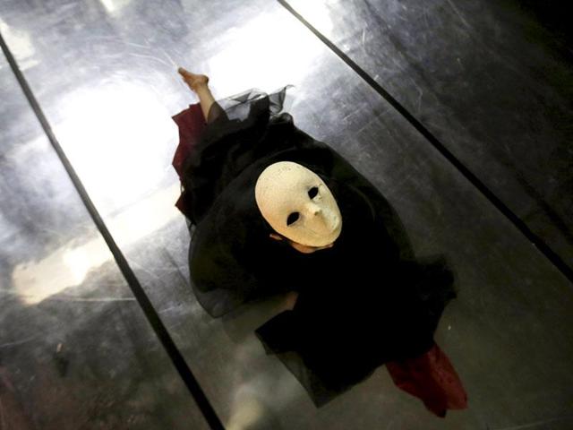 A mask-wearing dancer from Beijing Dance Theatre performs Ye Yan at the Poly Theatre in Beijing. (Reuters)
