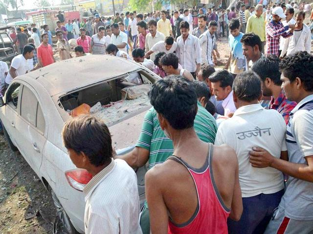 Locals looking at a damaged car near a collapsed restaurant where a cooking gas cylinder exploded in Petlawad town in Jhabua district of Madhya Pradesh on Saturday. (PTI Photo)
