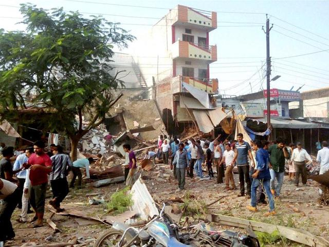 Locals gather near a collapsed restaurant where a cooking gas cylinder exploded in Petlawad town in Jhabua district of Madhya Pradesh. (PTI Photo)