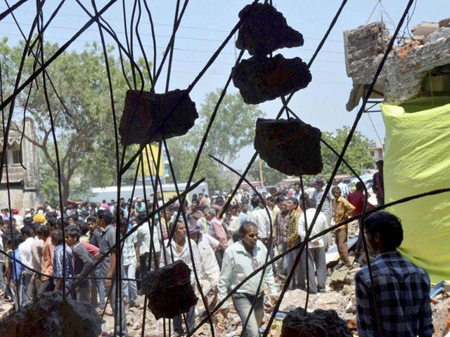 Onlookers gather at the site of Saturday’s explosion in the town of Petlawad, Jhabua in central Madhya Pradesh. (PTI Photo)