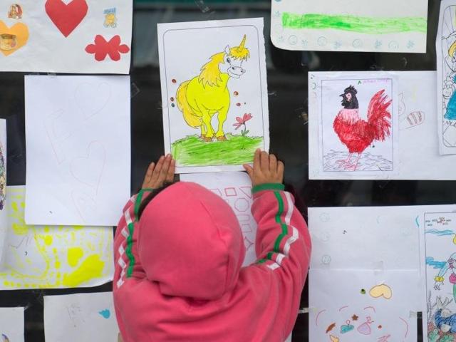 A migrant child looks at a unicorn drawing during the Muslim holiday of Eid al-Adha in a shelter at a former shopping mall in Graz, about 190 kms (118 miles) south of Vienna, Austria. (AP)