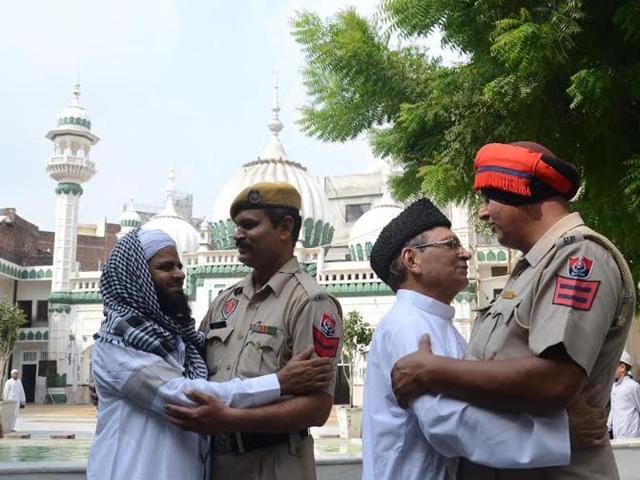 People of the Muslim community wishing Eid Mubarak to the policemen on guard after offering prayers in Amritsar on Friday. (Sameer Sehgal/HT)