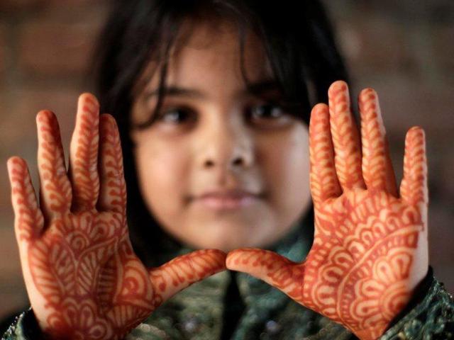 A Bangladeshi girl shows her decorated hands with hena painting, during the Eid al Adha festival in Dhaka, Bangladesh. (EPA)