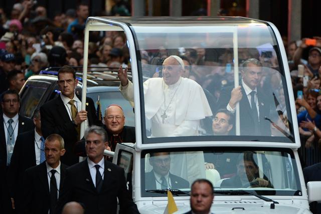 Pope Francis waves to gathered crowds as he makes his way down Fifth Avenue towards St. Patrick's Cathedral in New York on September 24, 2015. (AFP Photo) Pope Francis waves to gathered crowds as he makes his way down Fifth Avenue towards St. Patrick's Cathedral in New York on September 24, 2015. (AFP Photo)