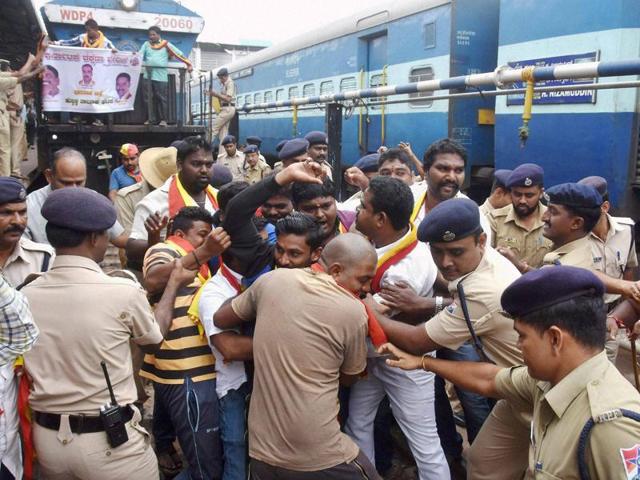 Police remove Karnataka Rakshana Vedike activists who were trying to stop a train during Karnataka bandh at Hubli in Karnataka on Saturday. (PTI photo) Police remove Karnataka Rakshana Vedike activists who were trying to stop a train during Karnataka bandh at Hubli in Karnataka on Saturday. (PTI photo)