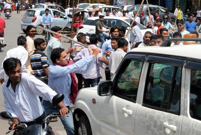 A protester attacks a vehicle after violence between two communities in Ranchi. (Diwakar Prasad (HT Photo))