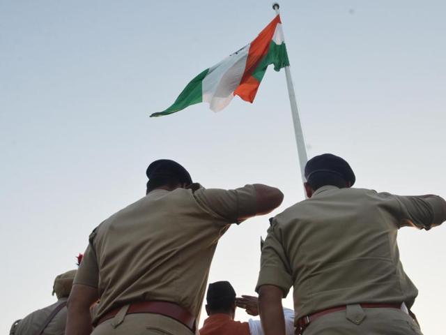 Policemen on duty salute the 170 feet high tricolour hoisted at Amrit Anand park, Ranjeet Avenue in Amritsar on Sunday. (Sameer Sehgal/HT Photo)