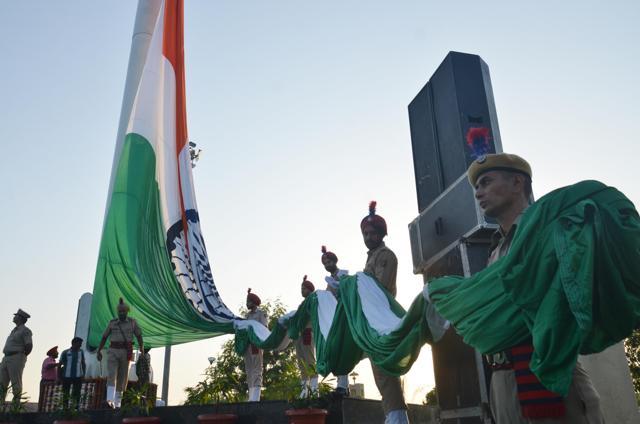 Cops on duty hold the 40 feet long Tricolour, which would fly at a height of 170 feet in Amritsar during its hoisting ceremony in Amritsar on Sunday. (Sameer Sehgal/HT Photo)