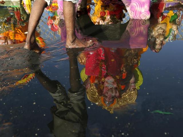An idol is immersed in polluted Yamuna river on Ganesh Chaturdashi, the immersion day, in New Delhi, on Monday. (Ravi Choudhary/ Hindustan Times)