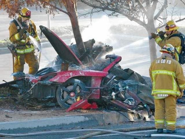 Firefighters extinguish the fire in the car where actor Paul Walker was killed. (DAN WATSON/Reuters)